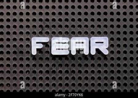 Weißer Buchstabe in Wort Angst auf schwarzem Pegboard Hintergrund Stockfoto