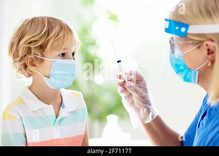 Coronavirus-Impfung. Covid-19-Impfstoff. Arzt, der Kind impft. Kinder in der Klinik. Kleiner Junge, der eine Grippeimpfung erhalten hat. Kinderarzt untersucht Kind Stockfoto