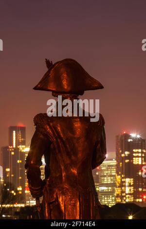 England, London, Greenwich, Silouette der Lord Nelson Statue und die Canary Wharf Skyline bei Nacht Stockfoto