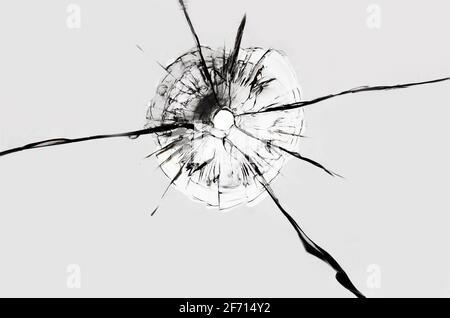 Loch im Glas auf weißem Hintergrund. Textur von gebrochenen Glasrissen, Abstraktion für Design. Stockfoto