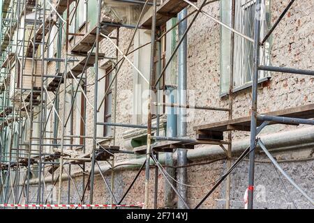 Renovierung des alten Gebäudes. Gerüste bei der Reparatur der Fassade eines mehrstöckigen Wohngebäudes. Stockfoto