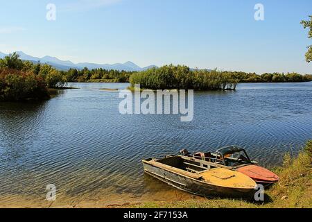 Landschaft mit dem Bild eines Bootes am Ufer des Flusses Angara. Sommer in Sibirien. Burjatien Stockfoto