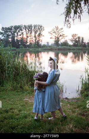 Die Mutter umarmt ihre Tochter im Freien in der Natur Stockfoto