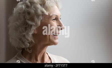Seitenansicht Porträt einer glücklichen alten 70er Jahre Frau, die wegschaut Stockfoto