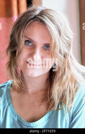 Porträt einer jungen blauäugigen Frau mit blondem lockigen Haar Stockfoto