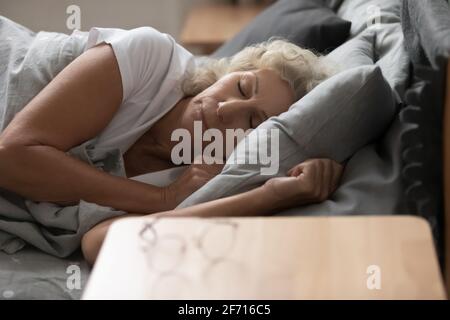 Ruhige, friedliche, gesunde ältere Frau, die gerne schläft Stockfoto