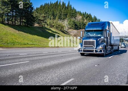 Kommerzielles großes Rig blau industriell grade Langstrecke professionelle semi LKW, der Ladung in einem trockenen Transporter transportiert, fährt weiter Das geteilte mehrzeilige Stockfoto