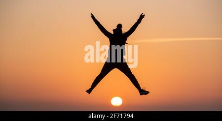 Bournemouth, Großbritannien. April 2021. Genießen Sie den Moment, in dem die Sonne am Ostertag am Hengistbury Head in Bournemouth, Dorset, aufgeht, am Beginn eines hellen und sonnigen Tages an der Südküste. Kredit: Richard Crease/Alamy Live Nachrichten Stockfoto