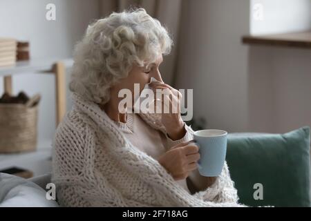 Kranke ältere Dame aus den 60er Jahren, die an Erkältung oder Grippe leidet Stockfoto
