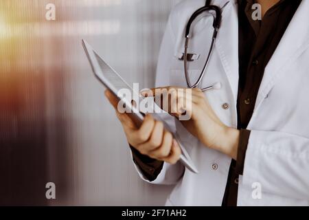 Unbekannte Ärztin mit Tablet-Computer in sonnigen Klinik. Perfekter medizinischer Service im Krankenhaus Stockfoto