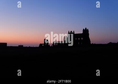 Whitby Abbey Silhouette bei Sonnenuntergang in Whitby, North Yorkshire, Großbritannien Stockfoto