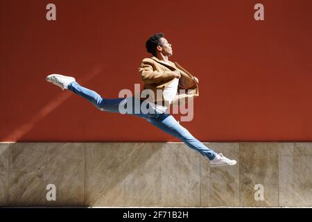 Schwarzer, athletischer Mann, der einen akrobatischen Sprung im Freien macht Stockfoto