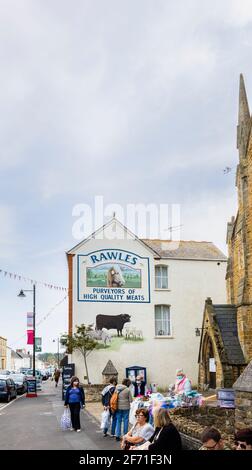 Rawles Metzger malte ein Namensschild an der Seite seines Ladens in der East Street im Stadtzentrum von Bridport, einer Marktstadt in Dorset, Südwestengland Stockfoto