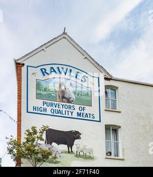 Rawles Metzger malte ein Namensschild an der Seite seines Ladens in der East Street im Stadtzentrum von Bridport, einer Marktstadt in Dorset, Südwestengland Stockfoto