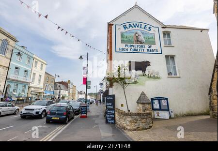 Rawles Metzger malte ein Namensschild an der Seite seines Ladens in der East Street im Stadtzentrum von Bridport, einer Marktstadt in Dorset, Südwestengland Stockfoto