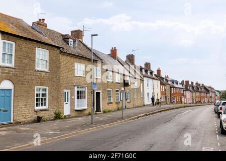 Typische Reihenhäuser mit Reihenhäusern und das Quaker Friends Meeting House gegenüber der South Street, Bridport, einer Marktstadt in Dorset, SW-England Stockfoto