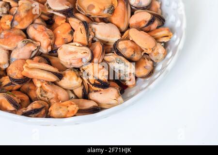 Gekochte Muscheln auf einem Teller auf weißem Hintergrund. Stockfoto