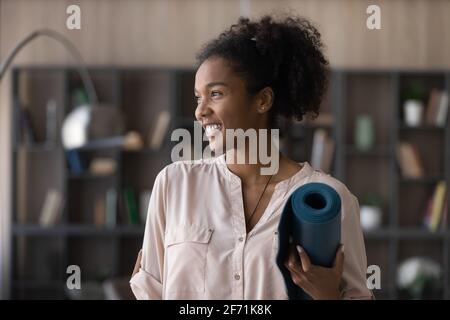 Lächelnde junge Birazialfrau bereit für das Sporttraining Stockfoto