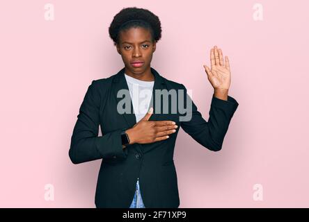 Junge afroamerikanische Mädchen trägt Business-Kleidung Fluchen mit Hand auf der Brust und offene Handfläche, so dass eine Loyalität Versprechen Eid Stockfoto
