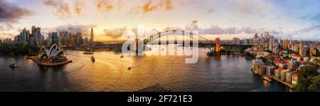 Farbenfrohes Luftpanorama über den Hafen von Sydney mit beiden Seiten der Hafenbrücke zwischen der CBD-Küste der Stadt und der Nordküste. Stockfoto