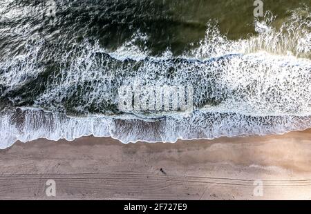 03. April 2021, Schleswig-Holstein, Westerland/Sylt: Wellen krachen am Sandstrand auf der Ostseite der Insel Sylt bei strahlendem Sonnenschein. (Luftaufnahme mit Drohne) Foto: Axel Heimken/dpa Stockfoto