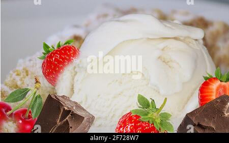 Eiscreme mit Erdbeeren, Schokolade und Kirschen, Rahm und anderen Eiswürfeln überspritzen Stockfoto