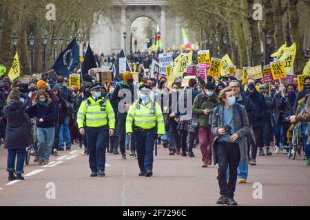 London, Großbritannien. April 2021. Demonstranten laufen am Wellington Arch vorbei, um zum Buckingham Palace zu gelangen, wo sie am Kill the Bill march vorbeiziehen. Tausende von Menschen marschierten durch das Zentrum Londons, um gegen das Gesetz über Polizei, Verbrechen, Verurteilung und Gerichte zu protestieren. Stockfoto