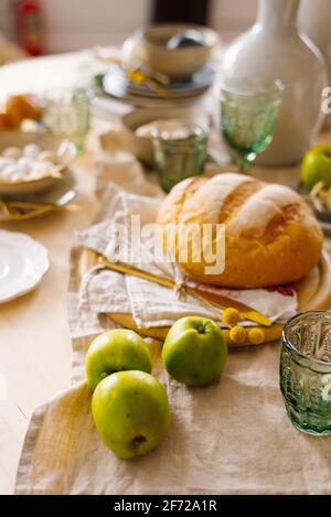 Grüne Äpfel, hausgemachtes frisches Weizenbrot. Frühstück wird zu Hause serviert Stockfoto