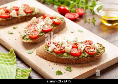 Bruschetta-Vorspeisen mit Kirschtomatos-Pesto und Mozzarella Stockfoto