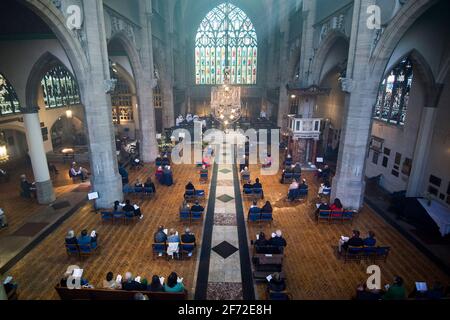 Mitglieder der Gemeinde soziale Distanz während des Ostersonntagsgottesdienstes in der Holy Trinity Sloane Square Kirche in Chelsea, London. Bilddatum: Sonntag, 4. April 2021. Stockfoto