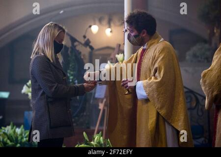 Während des Ostersonntagsgottesdienstes in der Holy Trinity Sloane Square Church in Chelsea, London, nehmen Mitglieder der Kongregation die heilige Kommunion von Reverend Fergus Butler-Gallie ab. Bilddatum: Sonntag, 4. April 2021. Stockfoto