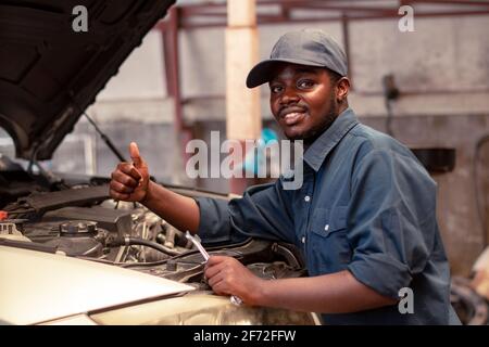 Afrikanische Wartung männlichen Service Überprüfung Motorsystem in der Garage Stockfoto