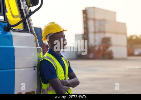 Ein schwarzer männlicher Arbeiter, der im Kofferraum eines steht Auto Stockfoto