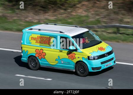 2014 VW Transporter T28 Startline TDI caravelle. Der Mystery Machine Scooby Doo Hundespazierdienst Volkswagen fährt auf der Autobahn M6 UK Stockfoto