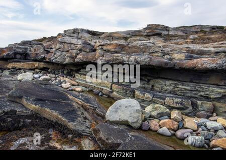 Natürliche Küstensteine und Schiefergestein, Küste des Arktischen Ozeans auf der Halbinsel Varanger, Finnmark, Norwegen Stockfoto