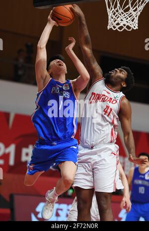 Zhuji, Chinas Provinz Zhejiang. April 2021. Dakari Johnson (R) von Qingdao Eagles blockiert Meng Zikai von den Tianjin Pioneers während des 52. Spielrunde in der Saison 2020-2021 der Liga der Chinesischen Basketballvereinigung (CBA) in Zhuji, der ostchinesischen Provinz Zhejiang, am 4. April 2021. Quelle: Li Ziheng/Xinhua/Alamy Live News Stockfoto