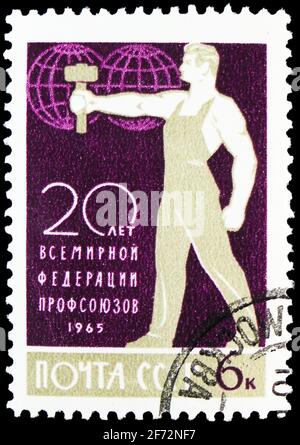 MOSKAU, RUSSLAND - 12. JANUAR 2021: Briefmarke gedruckt in der UdSSR (Russland) zeigt Weltverband der Gewerkschaften - Arbeiter mit Hammer, 20. Jahrestag Stockfoto