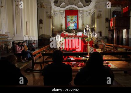 Gläubige im Gebet vor den Statuen des toten Christus und der schmerzhaften Jungfrau am Karfreitagabend, in der Kirche des Leibes Christi. Stockfoto