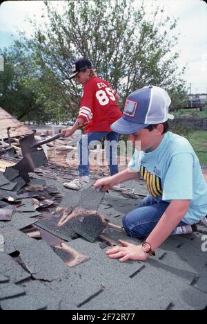 Midland TX, USA: Jugendliche Jungen entfernen abgenutzte Schindeln von einem Dach, während sie ehrenamtlich versuchen, Häuser von einkommensschwachen Bewohnern zu reparieren. ©Bob Daemmrich Stockfoto