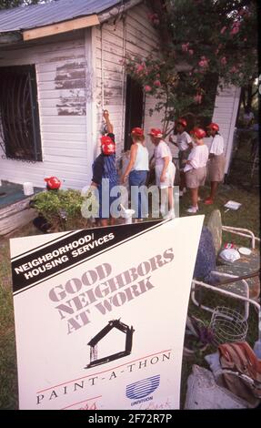 Freiwillige malen das Haus eines Einwohners mit geringem Einkommen während eines von der Stadt gesponserten „Paint-a-thon“ in San Antonio, TX, aus. Stockfoto