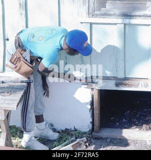 Austin, TX USA: Freiwilliger der Schreinerei-Klasse an High School führt dringend benötigte Reparaturen am Heim für ältere Männer mit niedrigem Einkommen durch. ©Bob Daemmrich Stockfoto