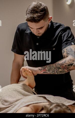 Junge Frau mit Füße Massage im Schönheitssalon, Nahaufnahme. Stockfoto