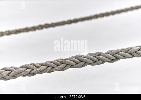 Zwei Segel-Seile, die vom Fischerboot oder von der Yacht hängen, aus der Nähe. Detailliertes Fragment des Seils. Stockfoto