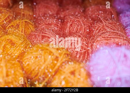 Close up of multicolored yarn balls in knitting shop center. A lot of color yarn for knitting. Colorful yarn wool on shopfront, macro. Stockfoto