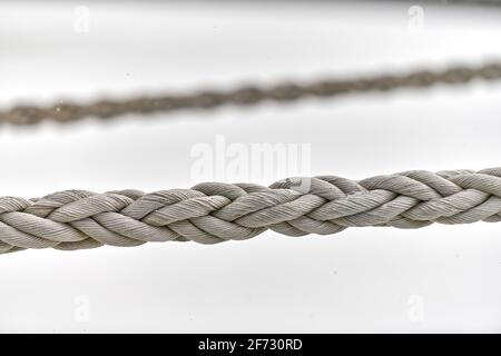 Zwei Segel-Seile, die vom Fischerboot oder von der Yacht hängen, aus der Nähe. Detailliertes Fragment des Seils. Stockfoto