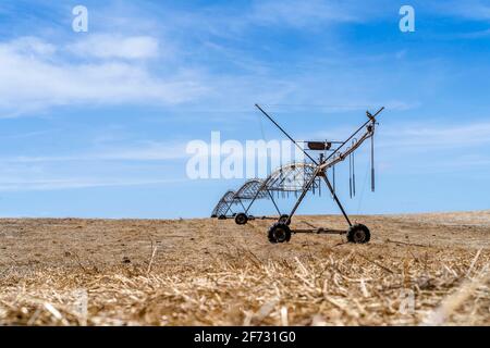 Bewegliches Bewässerungssystem auf einem trockenen Stoppelfeld in Alentejo, Portugal Stockfoto