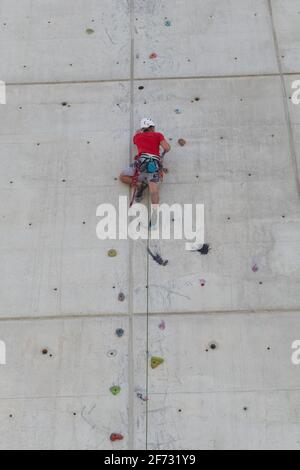 Klettertraining an einer senkrechten Wand in einer Kletterwand. Fitness, Extremsport, Menschen und gesundes Lifestyle-Konzept. Mann, der an der Kletterwand trainiert. V Stockfoto