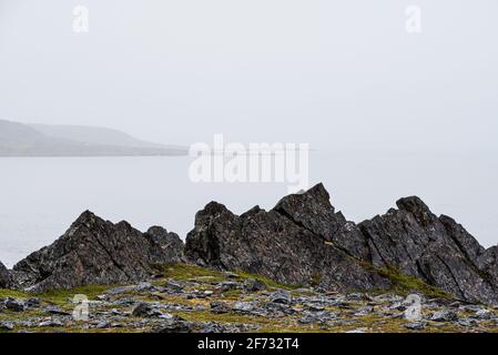 Küstensteine und Schiefergestein, Küste des Arktischen Ozeans auf der Halbinsel Varanger, Finnmark, Norwegen Stockfoto