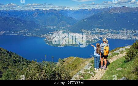 Mutter und Tochter blicken auf das Maggia-Delta mit Ascona und Locarno am Ende des Maggia-Tals, Monte Gambarogno, Lago Maggiore, Tessin Stockfoto