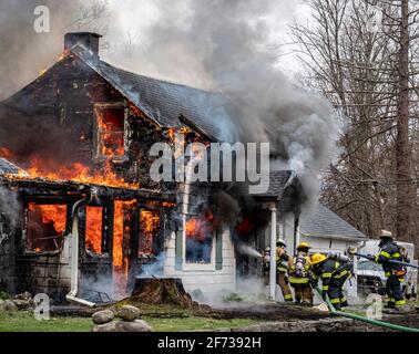 Feuerwehrleute kämpfen gegen das wütende Hausfeuer Stockfoto